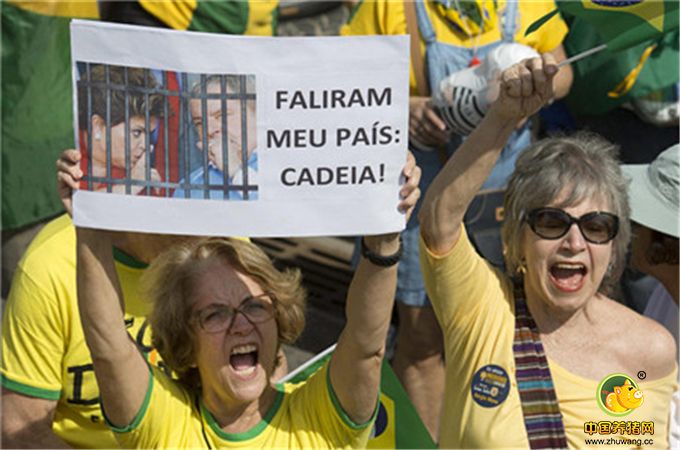 在里约热内卢，民众手举被停职的总统罗塞夫和前总统卢拉的照片，写着“你们毁了我们的国家”。此前，卢拉因涉贪腐遭调查。