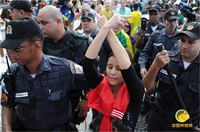 在里约，一名示威者在警察护送下离开。