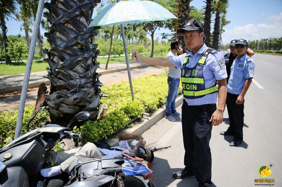 8月7日，海南三亚凤凰路槟榔河段，地面温度高达35℃左右。一名男子疑似醉酒撞树摔倒受伤，在等待120救护车前来救治的时间里，一名执勤民警主动为伤者撑伞守护，一直等到救护车赶到，这一温馨感人的小举动引起路过此地的市民群众称赞。