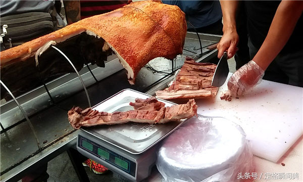 图为卖主称重猪肉。
