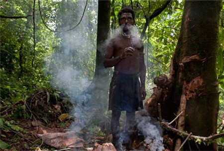 他们常年生活在深林里边，气候适宜，有时候很潮热，图片男子在抽部落烟