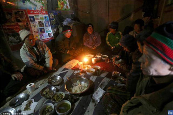 大家聚在一起吃早饭，因为屋里采光不好，白天只能用点蜡烛来照明。