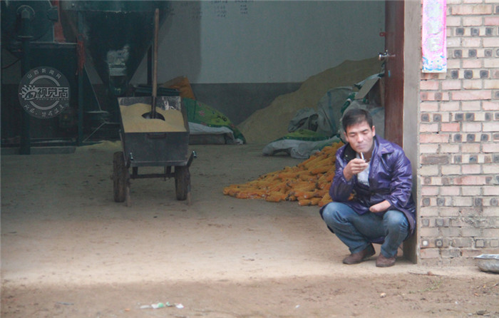 杨旭平忙里偷闲蹲着抽支烟。 